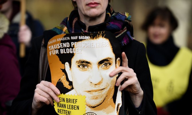 AFP/„Scanpix“ nuotr./Laikomas Saudo Arabijos blogerio Raif Badawi portretas