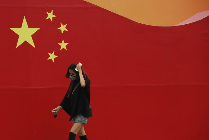 „Reuters“/„Scanpix“ nuotr./Praeivė Kinijos sostinėje Pekine