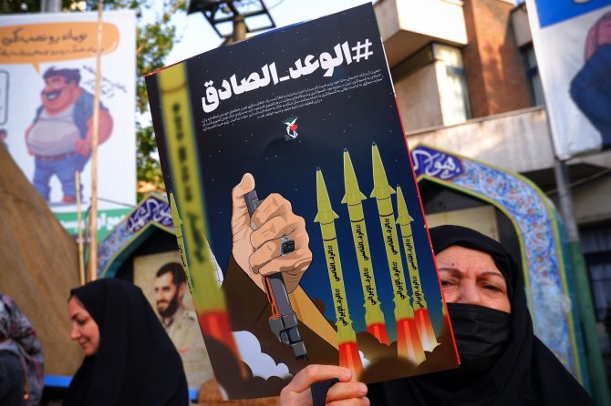 ZUMAPRESS / Scanpix nuotr./Irano rėmėja moteris laiko antiizraelietišką plakatą 