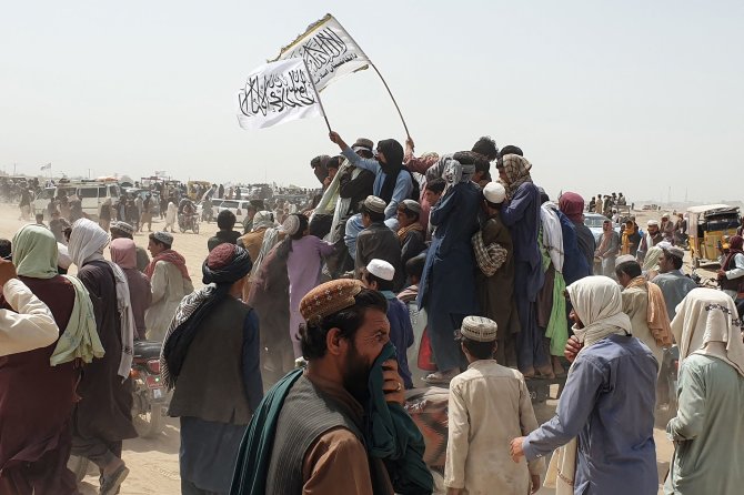 AFP/„Scanpix“ nuotr./Žmonės mojuoja Talibano vėliavomis Afganistano ir Pakistano pasienyje