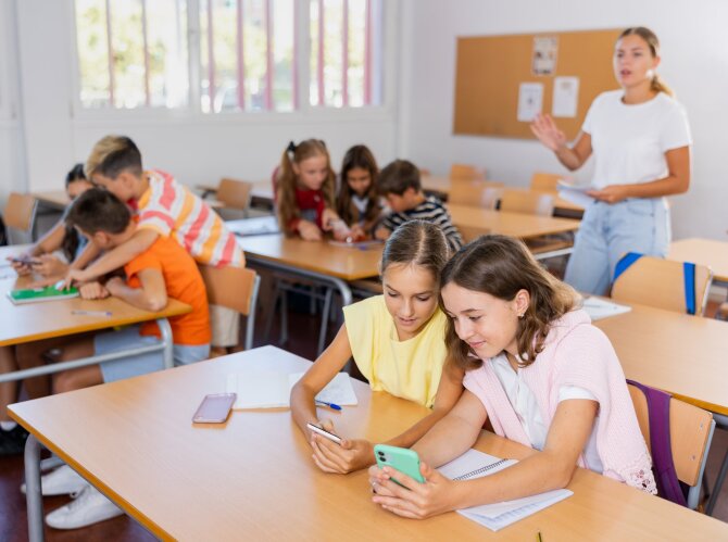 Shutterstock nuotr./Vaikai mokykloje naudojasi telefonu