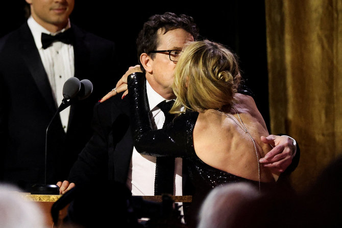 „Scanpix“ nuotr./Michaelas J. Foxas bučiuoja savo žmoną Tracy Pollan