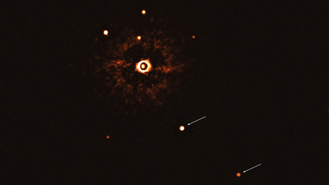  Bohn/ ESO/Žvaigždė TYC 8998-760-1 (viršuje centre) buvo nufotografuota su dviem milžiniškomis egzoplanetomis (rodyklės). Tai pirmas kartas, kai astronomai tiesiogiai nufotografavo daugiau nei vieną planetą, skriejančią aplink į saulę panašią žvaigždę. Ryškios dėmės virš žvaigždės TYC 8998-760-1 yra kitos žvai