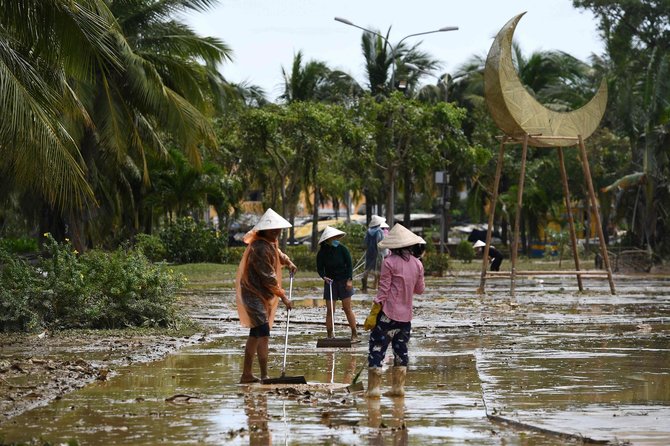 AFP/„Scanpix“ nuotr./Vietname gyventojai valo gatvę po praūžusio taifūno „Noru“ 2022 m. rugsėjo 29 d.