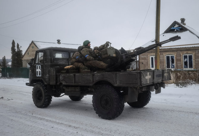 „Reuters“/„Scanpix“ nuotr./Ukrainos kariškiai važiuoja kariniu automobiliu su priešlėktuvine patranka ZU-23-2 fronto linijoje esančiame Vuhledaro mieste,