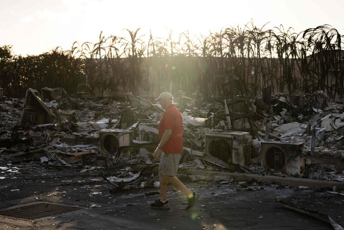 AFP/„Scanpix“ nuotr./Gyventojas apžiūrinėja apanglėjusį daugiabučių kompleksą po miškų gaisro Lahainoje, vakarų Maui, Havajuose