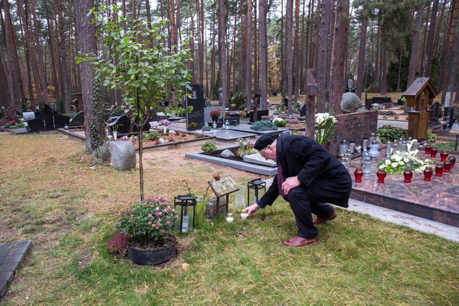 Petro Vaičiulio nuotr./Poeto Kęstučio Navako kukliai paženklintas kapelis Petrašiūnų kapinėse. Žvakę uždega Lietuvos rašytojų sąjungos Kauno skyriaus pirmininkas Gediminas Jankus, Vėlinių išvakarėse tradiciškai su kitais rašytojais aplankęs kolegų kapus.