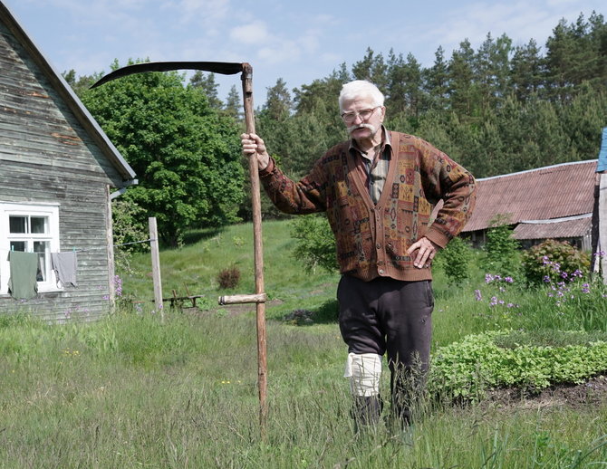 Brolių Černiauskų nuotr./Nepripažįsta Henrikas jokių šiuolaikinių žoliapjovių, trimerių ir kitų gudrių žmogaus sukurtų prietaisų, padedančių tvarkyti aplinką, o ir toliau kantriai mojuoja dalgiu kuriam nereikia benzino. Liškiava, 2022 m.