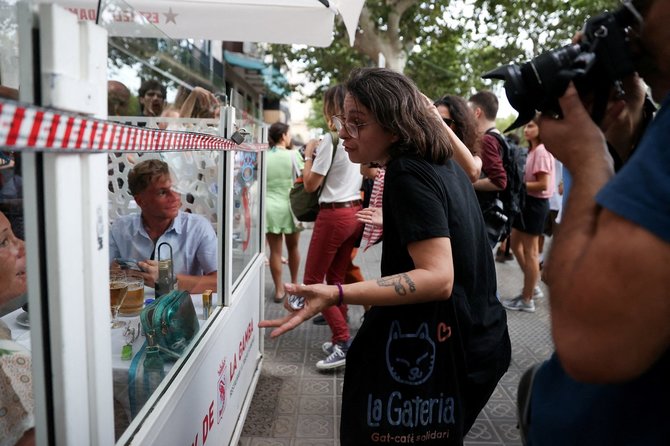 „Reuters“/„Scanpix“ nuotr./Protestuojai diskutuoja su turistais Barselonoje