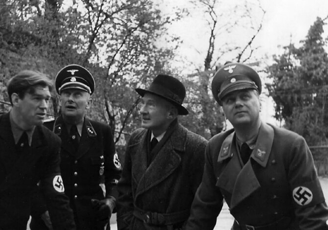 Leidyklos nuotr./Alfredas Rosenbergas (dešinėje), Billas de Roppas, SS karininkas pavarde Riemeris ir vienas iš Rosenbergo personalo narių krečia pokštus prieš kamerą per savo kelionę į Austriją 1938 metais.