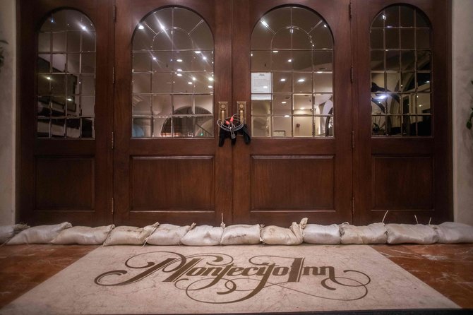 „AFP“/„Scanpix“/Uždaryto Montesito viešbučio durys užremtos smėliu užpildytais maišais