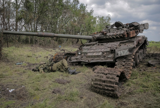 „Reuters“/„Scanpix“/Sužeistas rusų karys ir sunaikintas tankas