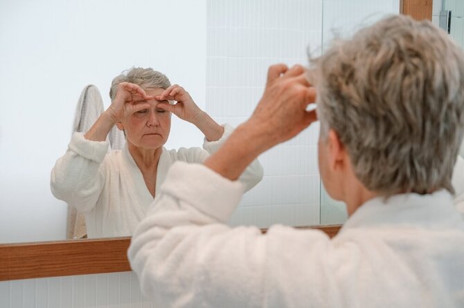 Shutterstock nuotr./Žiūrinti į veidrodį moteris