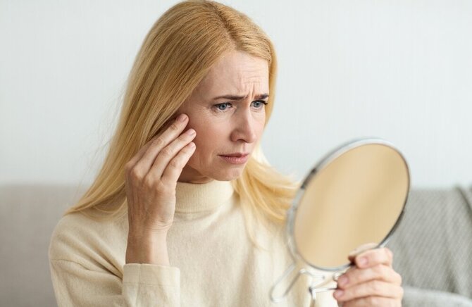 Shutterstock nuotr./Moteris, žiūrinti į veidrodį