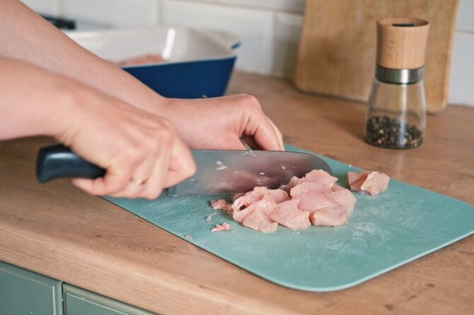 Shutterstock nuotr./Moteris pjausto vištieną