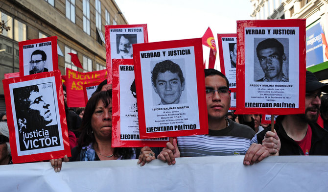 AFP/„Scanpix“ nuotr./Žmogaus teisių aktyvistai per demonstraciją Santjage neša žuvusių ir dingusių be žinios per Agusto Pinocheto diktatūros metus portretus (2011 m.)
