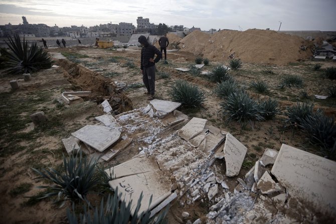 „Scanpix“/AP nuotr./Palestinečiai apžiūri iškasinėtus kapus Gazos Ruože.