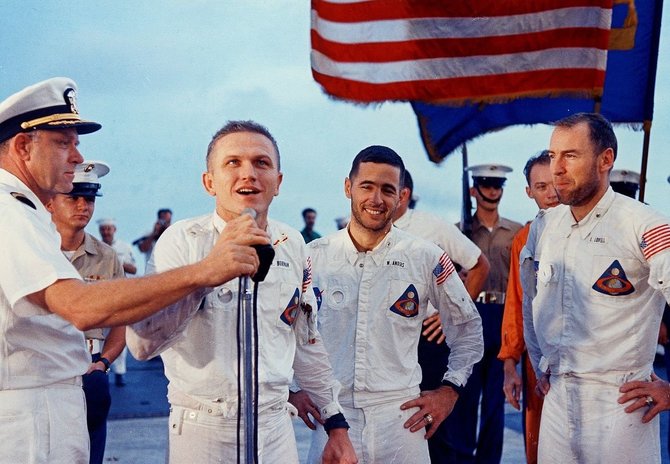 NASA nuotr./Į Žemę sugrįžę „Apollo 8“ astronautai Frankas Bormanas, Williamas Andersas ir Jamesas Lovellas sveikinasi su lėktuvnešio „Yorktown“ įgula.