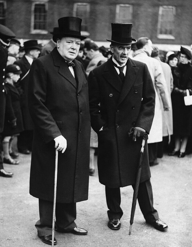Wikipedia.org nuotr./Winstonas Churchillis su politiniu oponentu Neville'iu Chamberlainu, iš kurio 1940 metais perėmė Britanijos premjero postą. Nuotrauka daryta 1935 m.