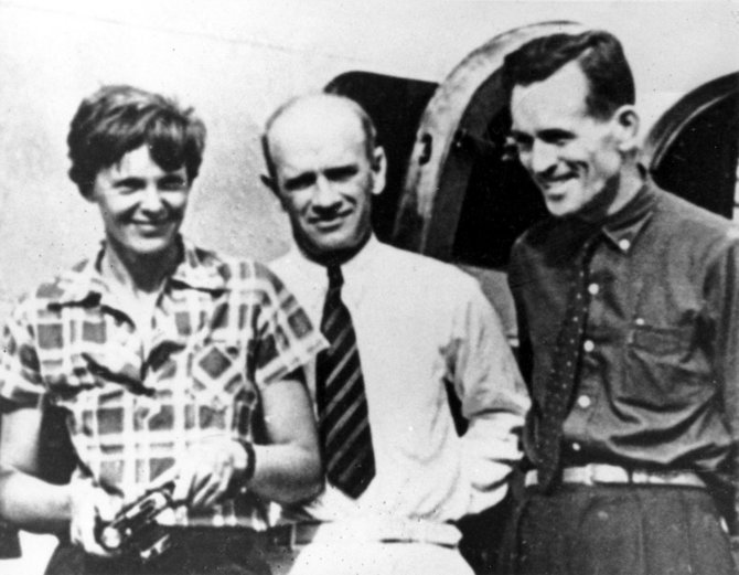 „Scanpix“/AP nuotr./Amelia Earhart ir Fredas Noonanas (dešinėje) su aukso kasyklų Naujojoje Gvinėjoje savininku F.C.Jacobsu prieš pat pakilimą į Houlando salą 1937 m. liepos 2 d.