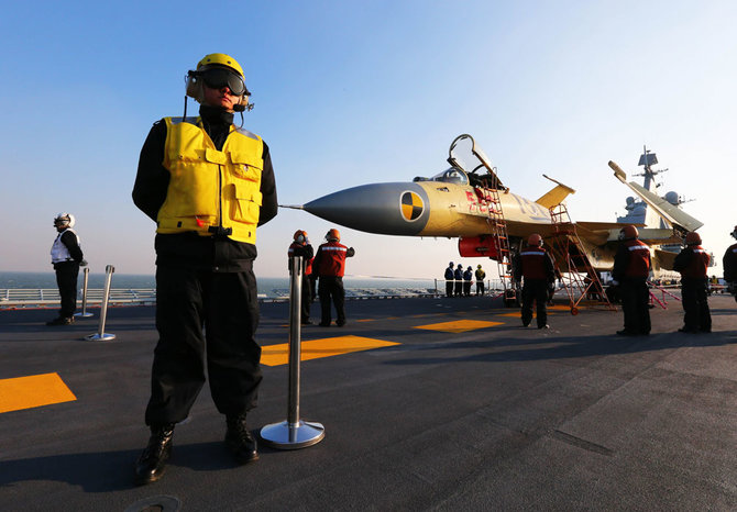 „Reuters“/„Scanpix“ nuotr./Ant lėktuvnešio „Liaoning“ denio bazuojasi Kinijos naikintuvas J-15