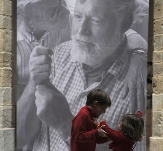 „Reuters“/„Scanpix“ nuotr./Vaikai prie Ernesto Hemingvėjaus portreto