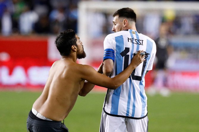 AFP/„Scanpix“ nuotr./Pusnuogis žiūrovas ir Lionelis Messi
