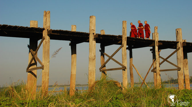 Budistų vienuoliai žingsniuoja ilgiausiu pasaulyje tikmedžio tiltu Amarapuros kaime, Mianmare