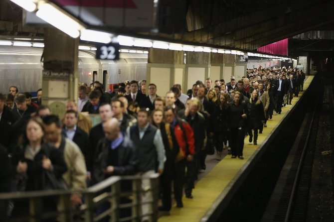 AFP/„Scanpix“ nuotr./Žmonės Niujorko metro stotelėje piko metu