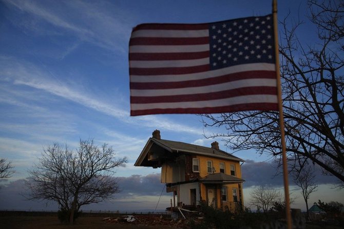„Reuters“/„Scanpix“ nuotr./JAV vėliava netoli Sandy audros sugriauto namo
