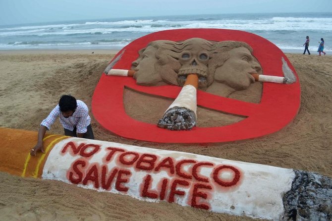 AFP/„Scanpix“ nuotr./Smėlio skulptoriaus darbas skirtas paminėti dienai be tabako
