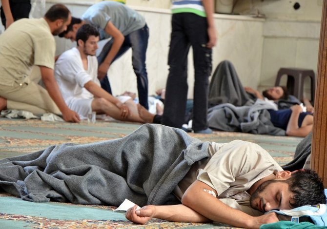 „Reuters“/„Scanpix“ nuotr./Sirijoje per dujų ataka apnuodyti žmonės