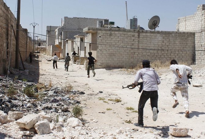 Laisvosios Sirijos armijos kovotojai bėga slėpti nuo snaiperių šūvių.