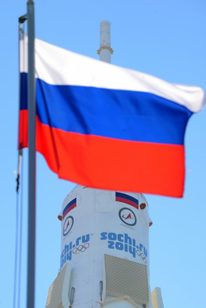 AFP/„Scanpix“ nuotr./„Sojuz FG“ raketa Rusijos vėliavos fone