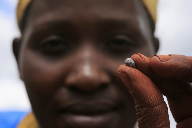 „Reuters“/„Scanpix“ nuotr./Aukso kasyklos darbuotojas rodo neapdirbto ausko gabalėlį.