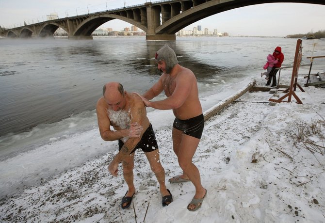 „Reuters“/„Scanpix“ nuotr./Rusijos žiemos plaukimo klubo nariai prie Rusijos žiemos plaukimo klubo narių maudynės Jenisejaus upės