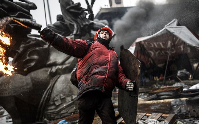 AFP/„Scanpix“ nuotr./Protestuotojas meta Molotovo kokteilį.