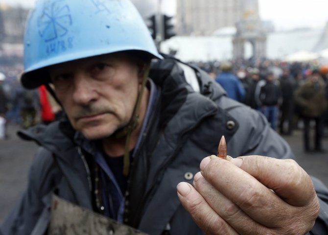 „Reuters“/„Scanpix“ nuotr./Kijeve vyras rodo kulką