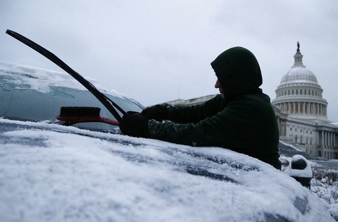 „Reuters“/„Scanpix“ nuotr./Nuo automobilio valomas sniegas