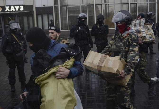 „Reuters“/„Scanpix“ nuotr./Kijeve iš „Dnipro“ viešbučio išeina „Pravyj sektor“ nariai