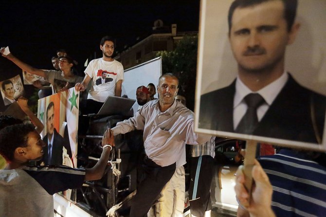 AFP/„Scanpix“ nuotr./Damaske žmonės šventė Basharo al Assado pergalę Sirijos prezidento rinkimuose.