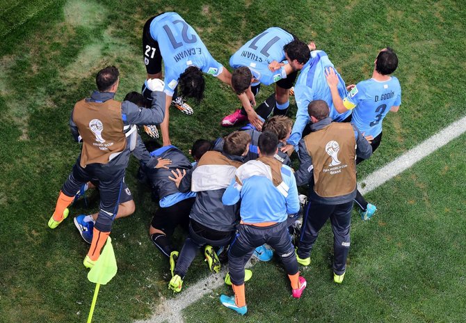 AFP/„Scanpix“ nuotr./Urugvajaus futbolininkai džiaugiasi nugalėję Anglijos rinktinę.