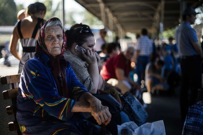 AFP/„Scanpix“ nuotr./Savo namus palikę ukrainiečiai laukia autobusų stotyje