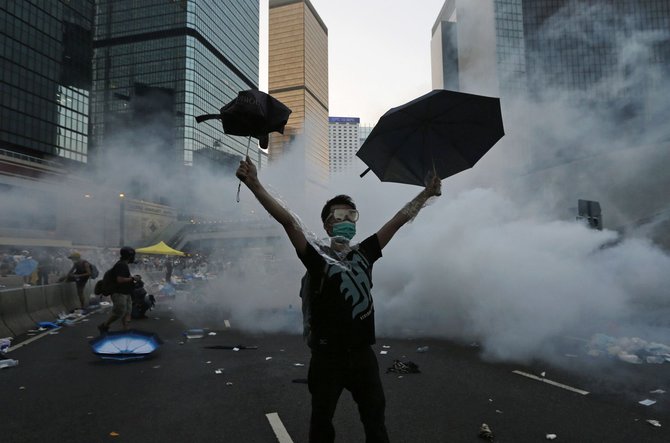 „Reuters“/„Scanpix“ nuotr./Honkonge protestuotojai buvo vaikomi panaudojus ašarines dujas.
