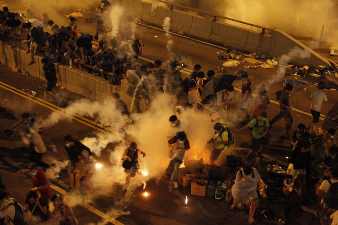 „Reuters“/„Scanpix“ nuotr./Honkonge protestuotojai buvo vaikomi panaudojus ašarines dujas.
