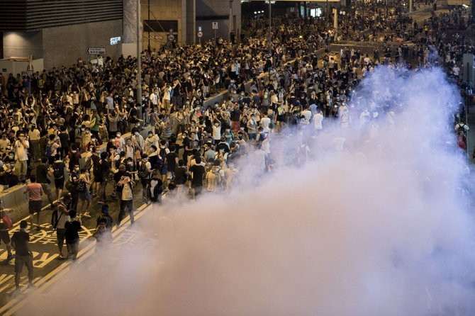 AFP/„Scanpix“ nuotr./Honkonge protestuotojai buvo vaikomi panaudojus ašarines dujas.