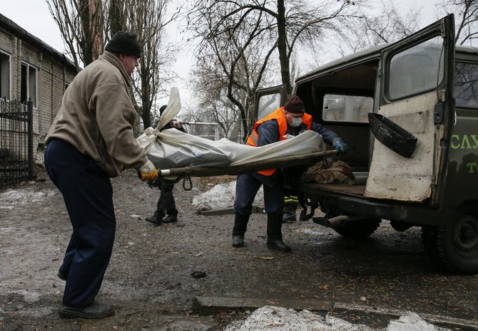 „Reuters“/„Scanpix“ nuotr./Donecko regione išnešamas žuvusio žmogaus kūnas.