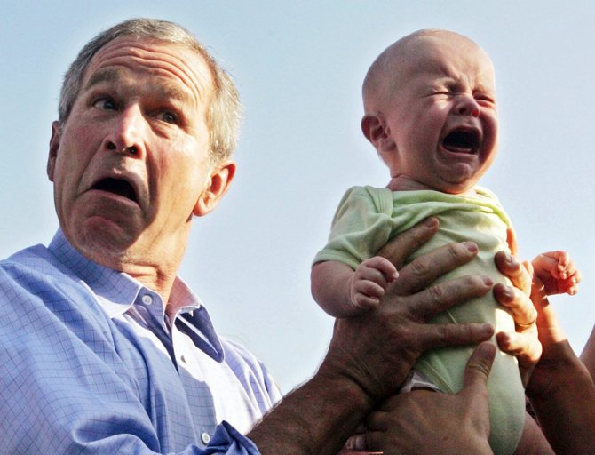 „Reuters“/„Scanpix“ nuotr./JAV prezidentas George W. Bushas per vizitą Vokietijoje gražina tėvams verkiantį vaiką (2006 m. liepos 13 d.)