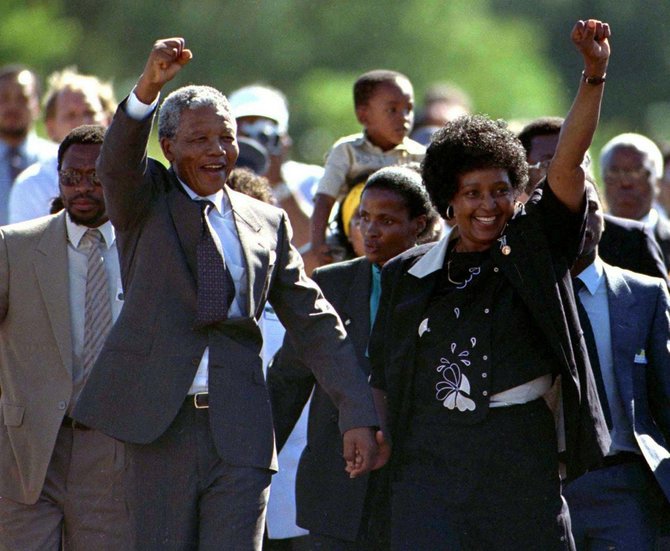 „Reuters“/„Scanpix“ nuotr./Nelsonas Mandela po paleidimo iš kelėjimo, kur praleido 27 metus, eina lydimas žmonos Winnie (1990 m. vasario 11 d.)