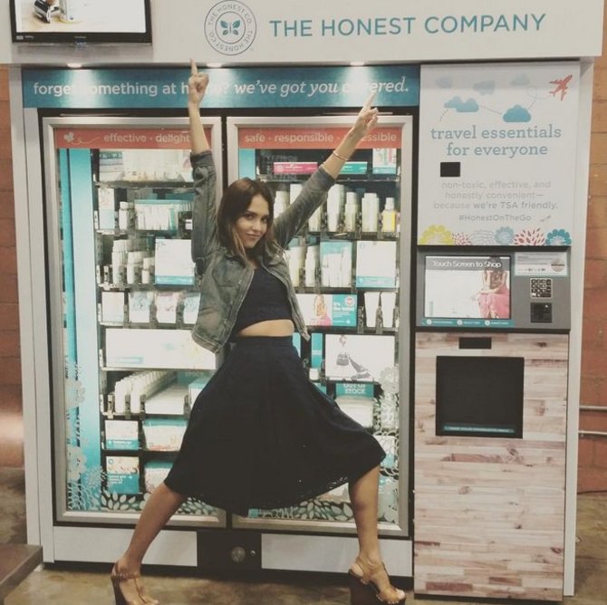 „Instagram“ nuotr./Jessica Alba prie savo produktų „Honest“ automato oro uoste